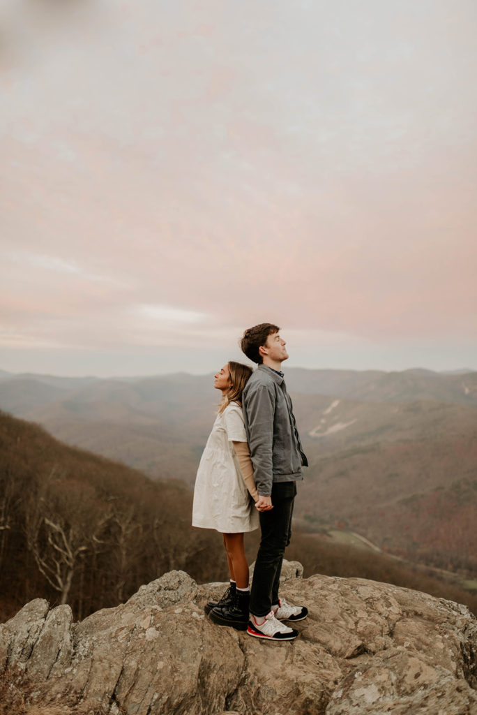Couple holds hands at surprise proposal overlook