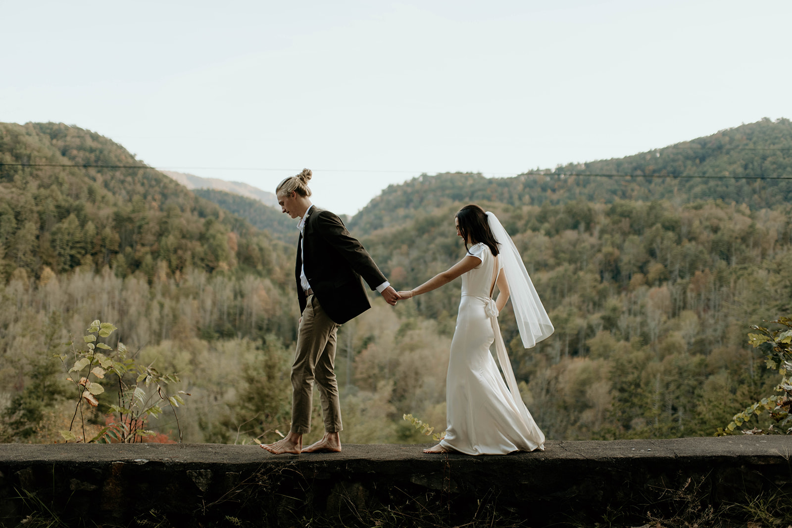 Couple walks holding hands at forest elopement
