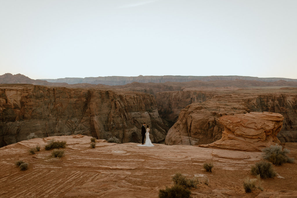 couple holds hands at horseshoe bend adventure session