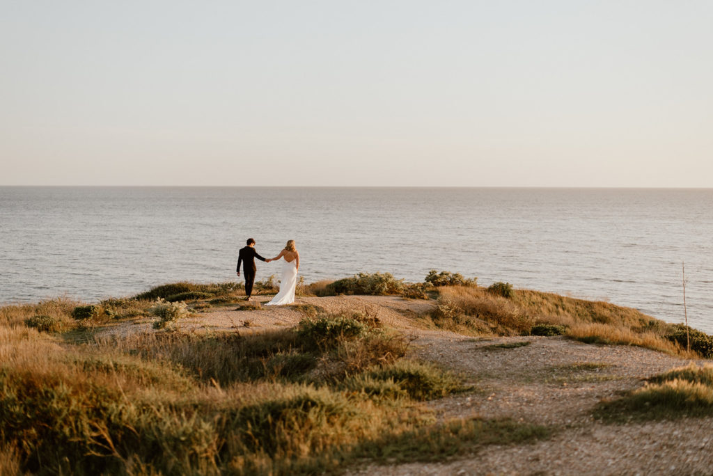 Couple walks holding hands at california coast adventurous elopement