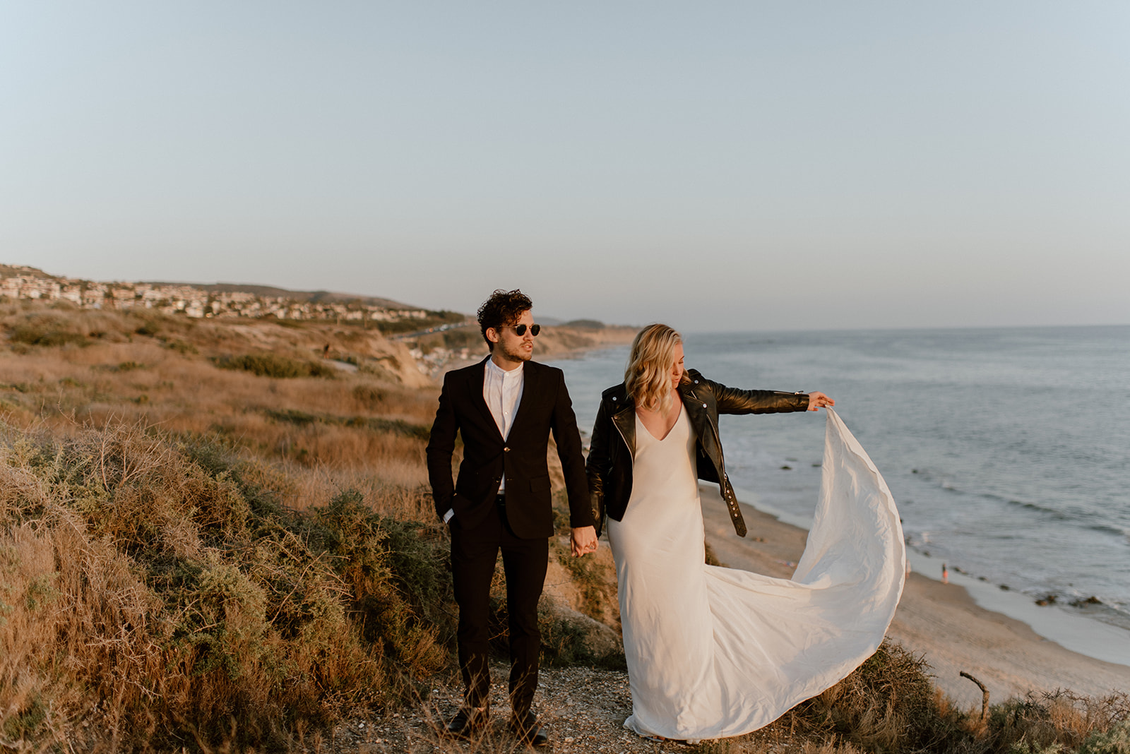 Couple stands on cliff at california coast elopement