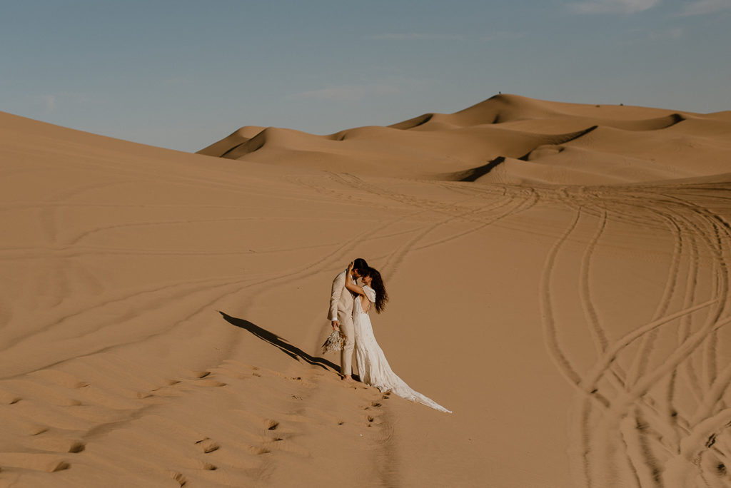 Couple embraces at sand dunes elopement