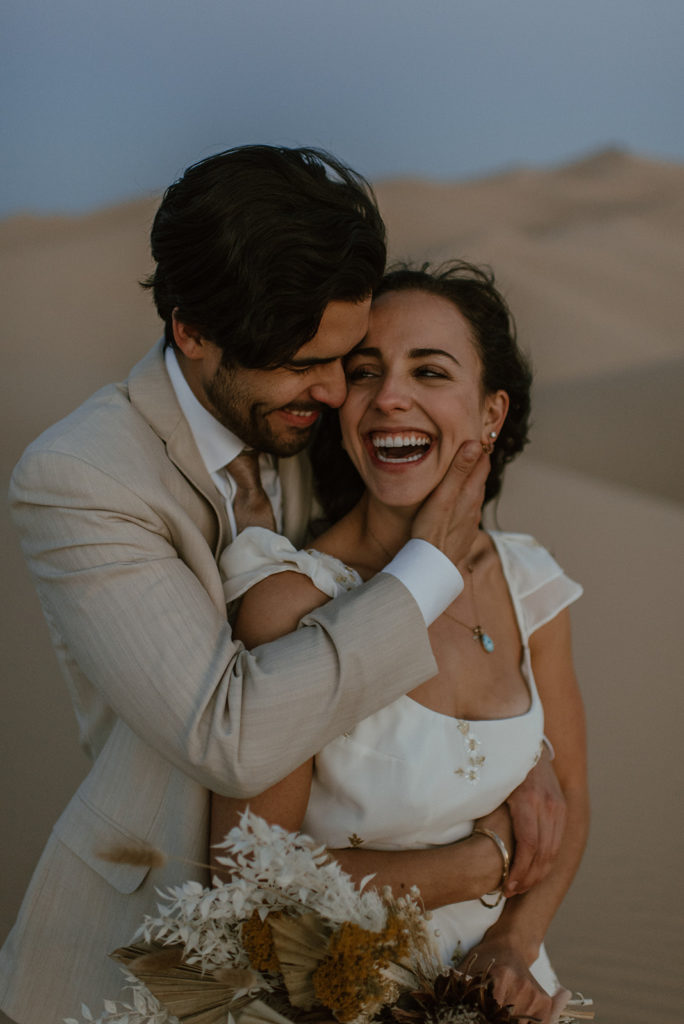 Couple embraces at sand dunes elopement