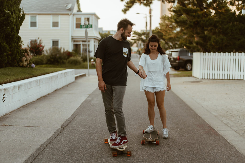Couple holds hands on longboards at adventure session