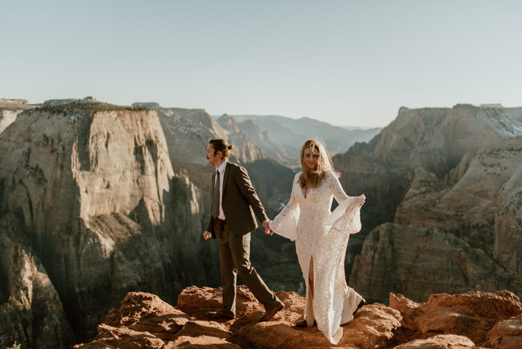 Couple holds hands at Zion overlook adventure elopement