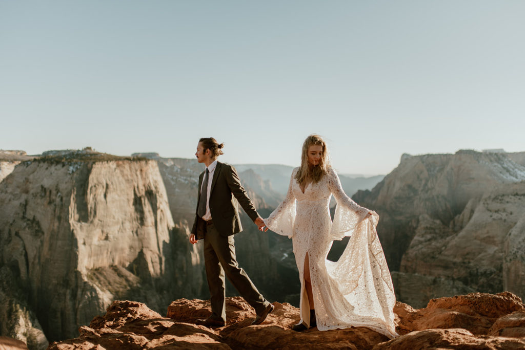 Couple holds hands at Zion overlook adventure elopement
