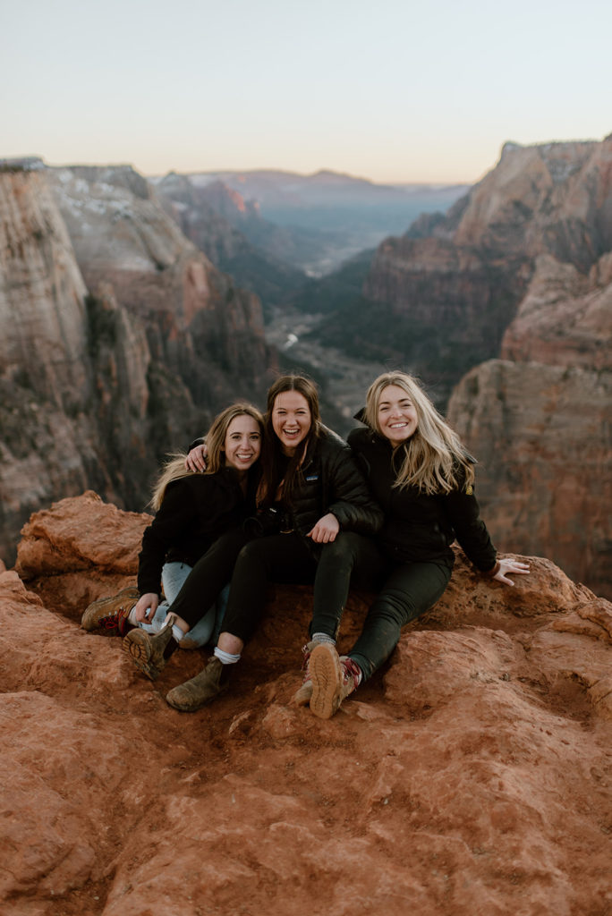 Photographer friends laugh together at Zion overlook adventure elopement