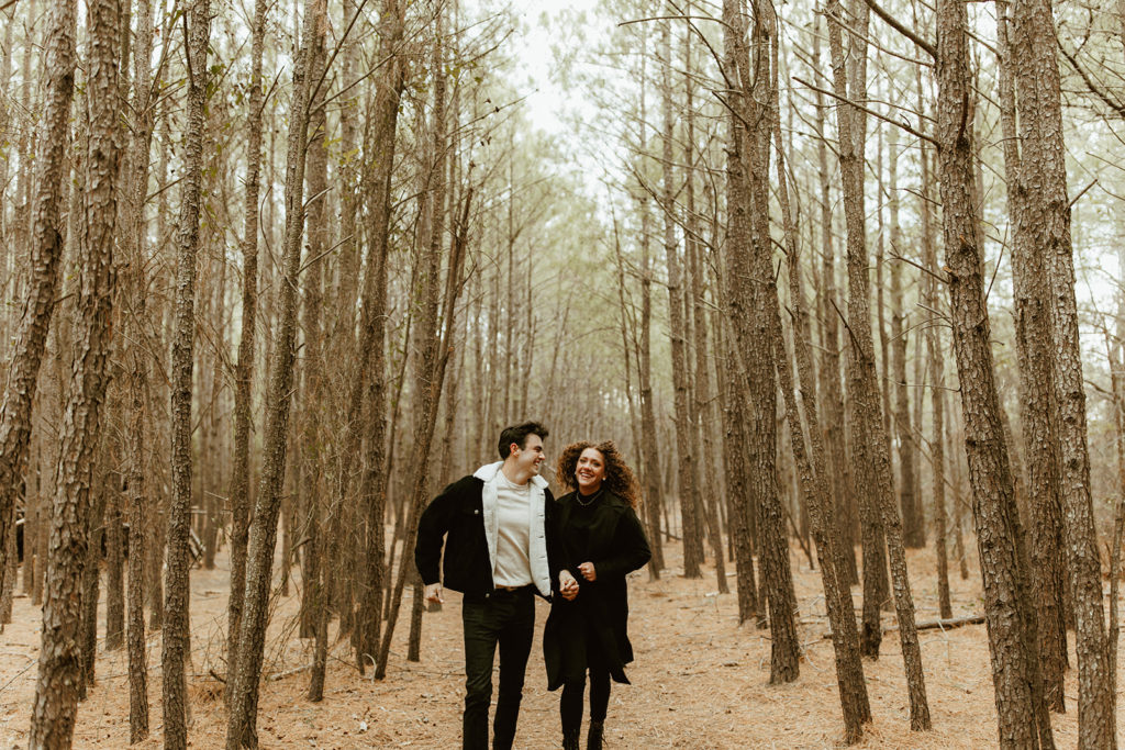 Couple runs through woods at Virginia engagement session captured by creative entrepreneur