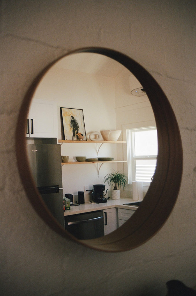Mirror reflecting a kitchen