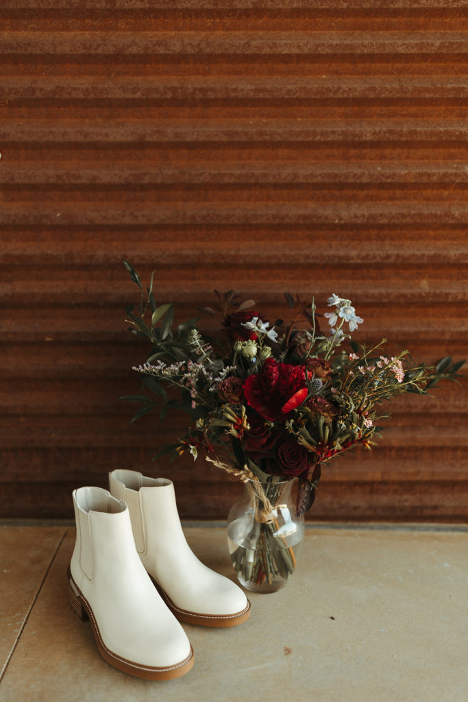 Wedding boots and wedding bouquet against wall