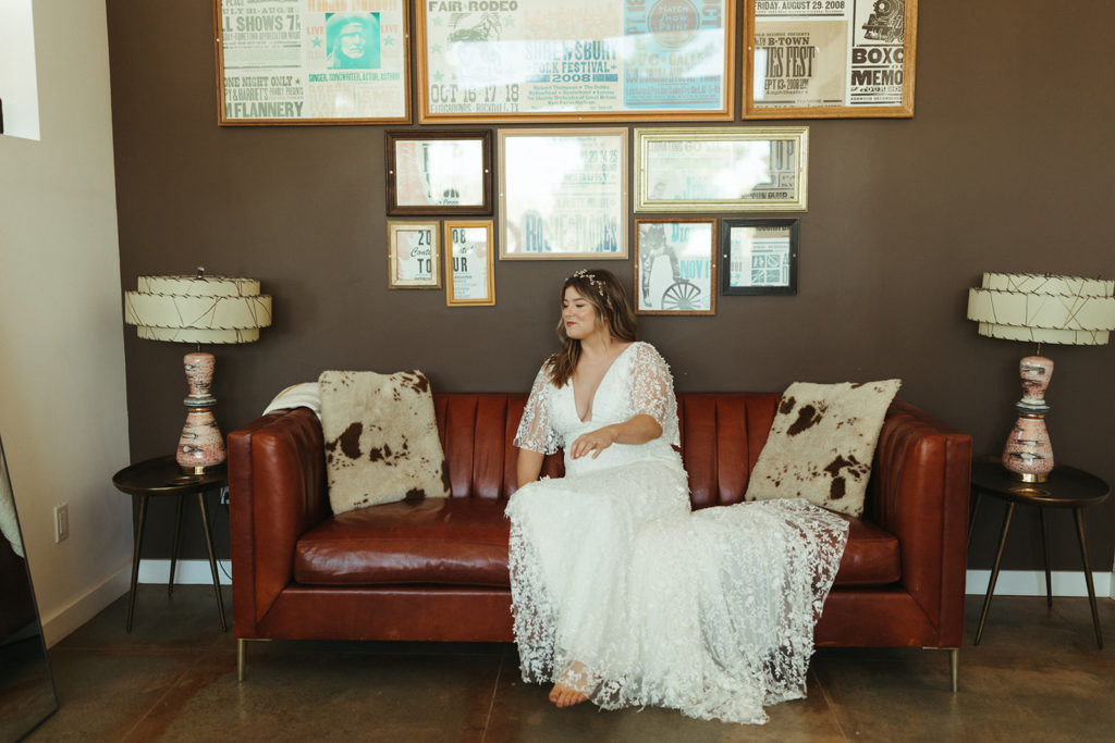 Bride sits on red couch at Joshua Tree elopement