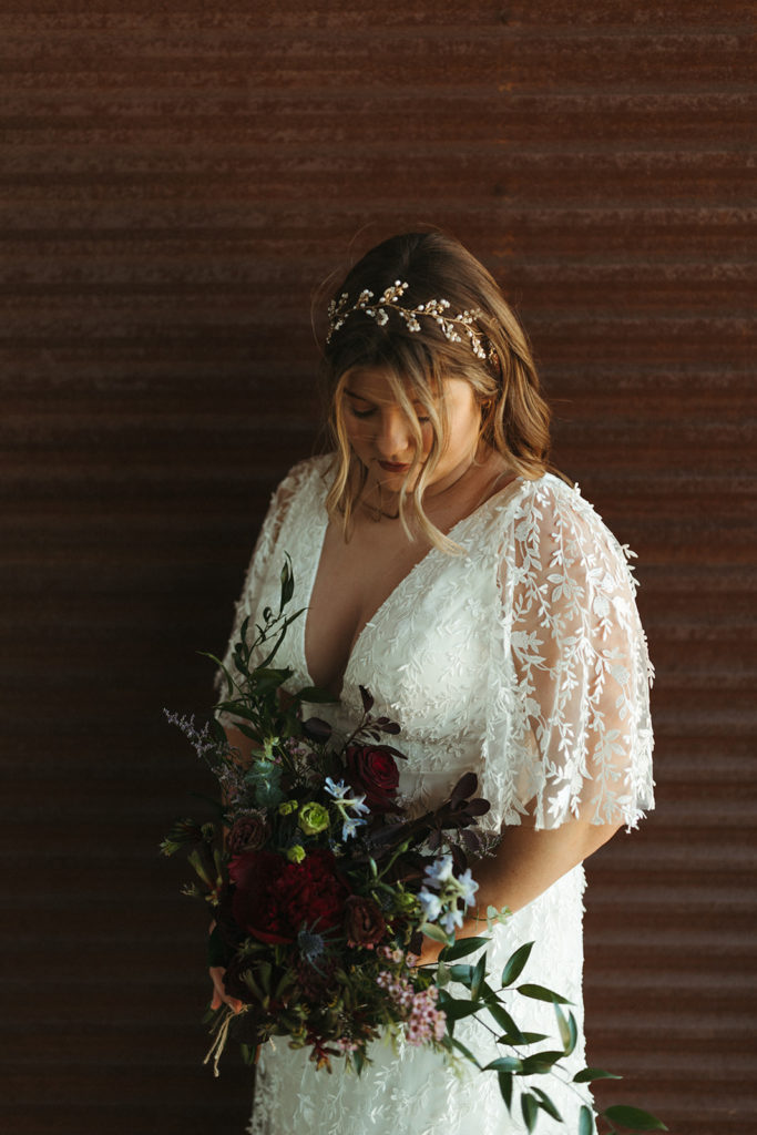 Bride stands holding wedding bouquet