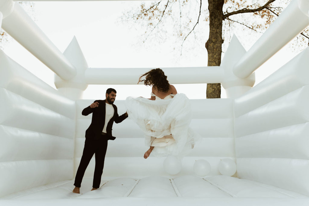 Couple jumps in bounce house at Atlanta, Georgia wedding