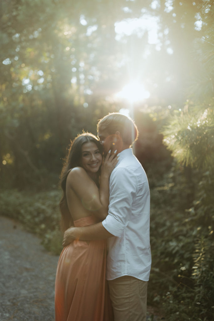 couple embraces at sunset in forest 