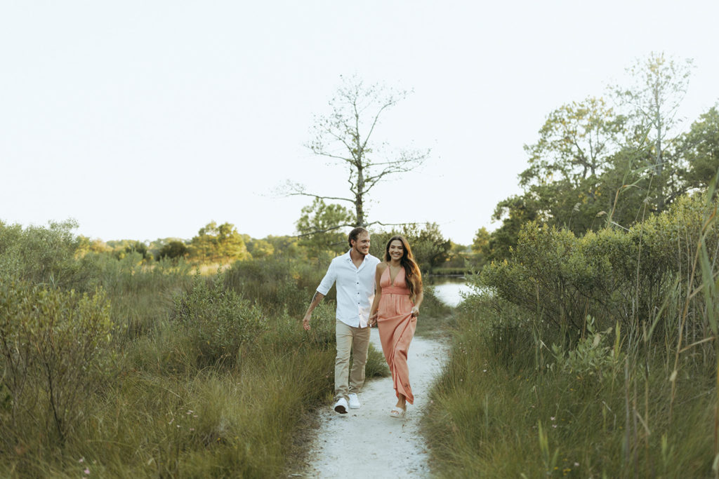 Couple walks through grassy Virginia Beach