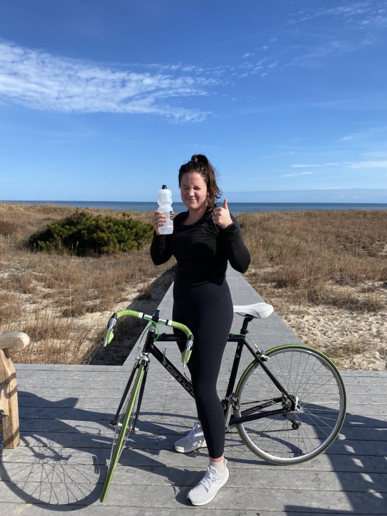 photographer stands beside bike on Virginia Beach boardwalk