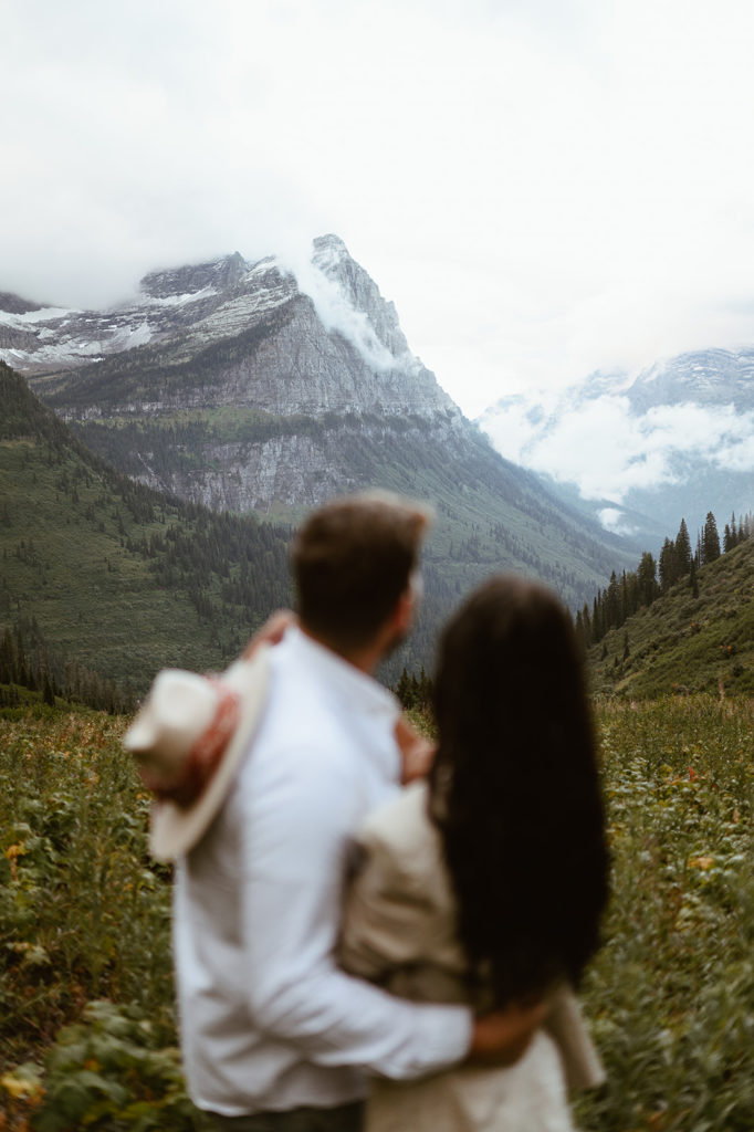 couple embraces in front of mountain at Glacier National Park elopement