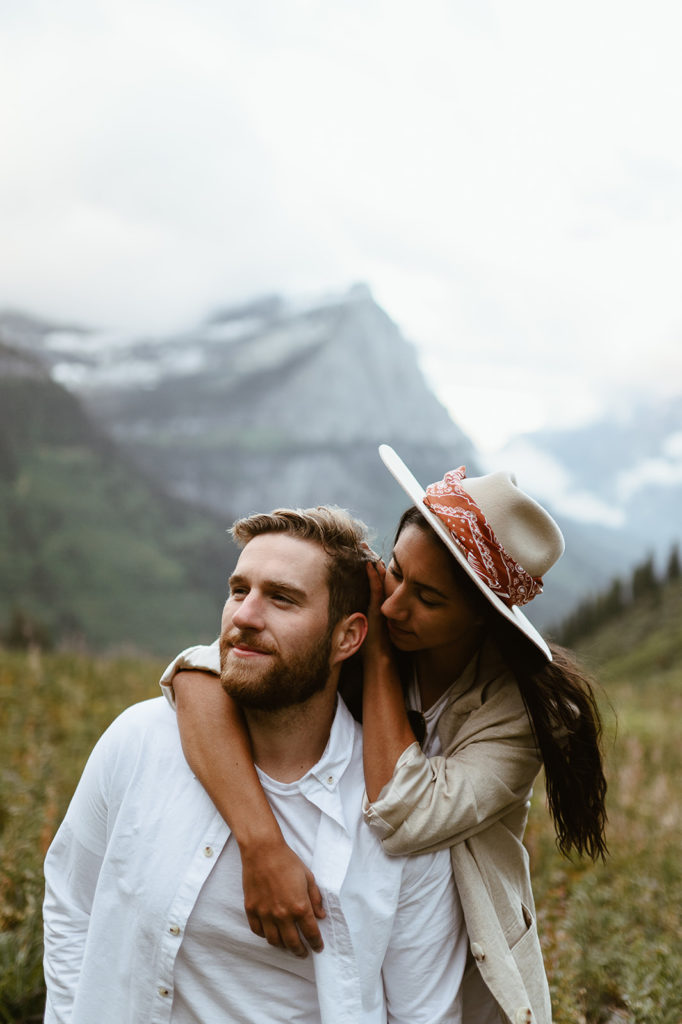 couple embraces in front of mountain at Glacier National Park elopement