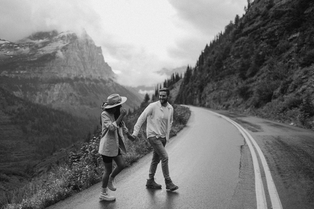 couple walks down street holding hands at Glacier National Park elopement

