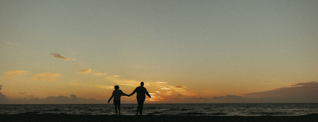 couple holds hands at sunrise couples session captured by travel photographer
