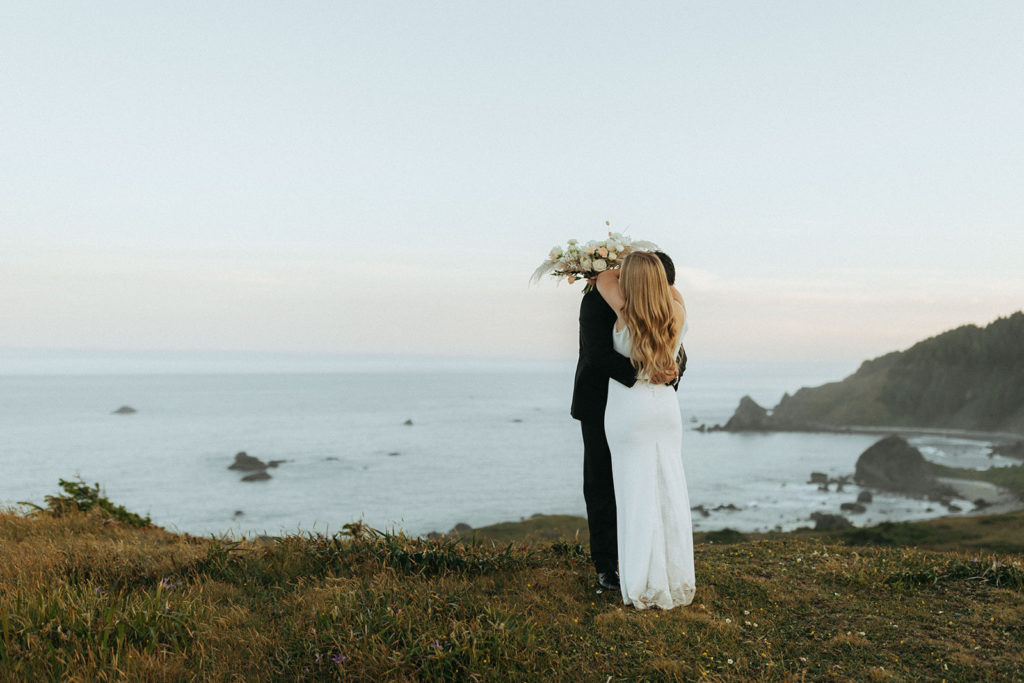 couple embraces at Oregon coast first look wedding photoshoot