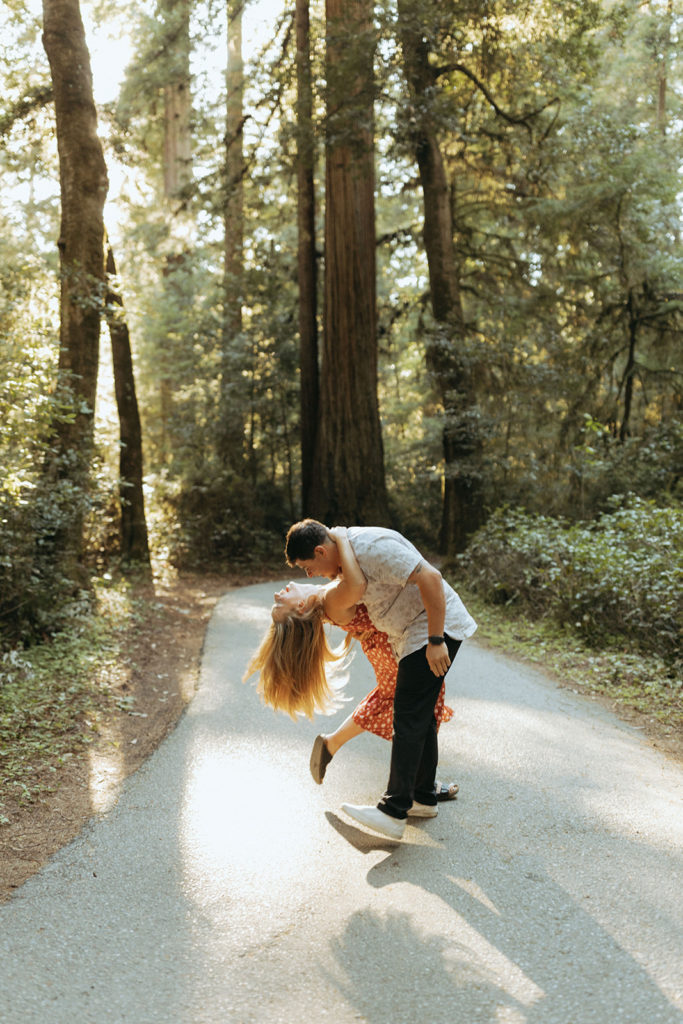 couple embraces on path in Redwoods engagement session