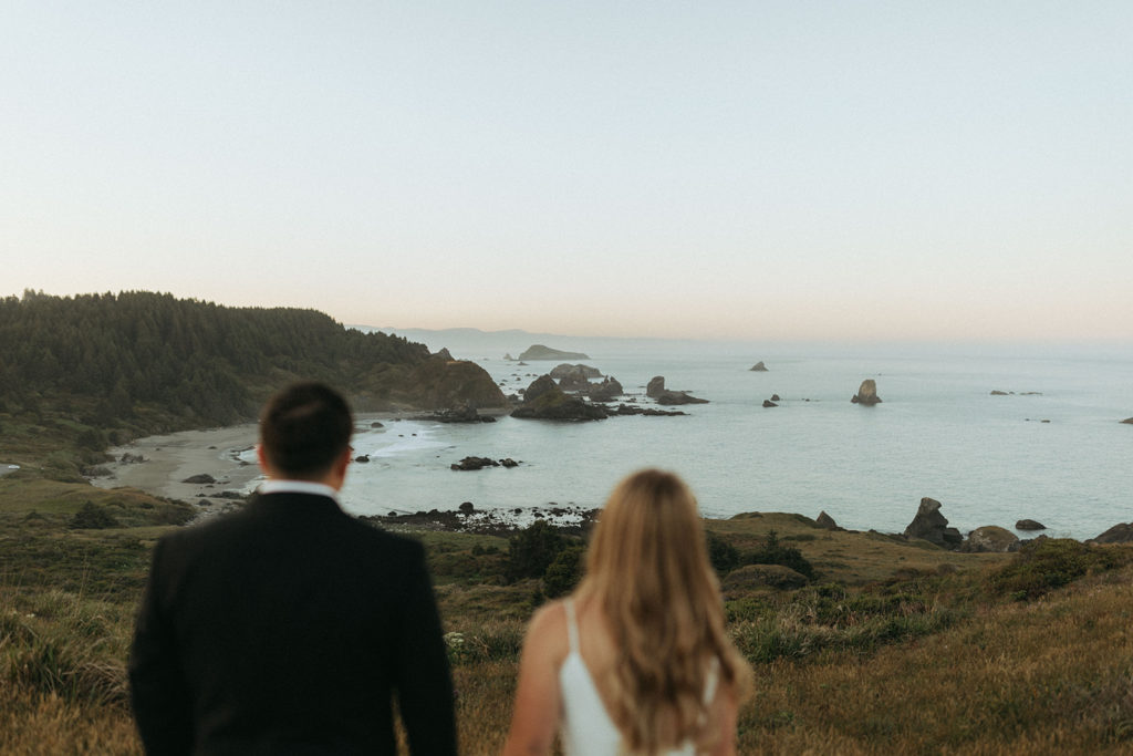 couple looks on Oregon Coast at elopement wedding photoshoot