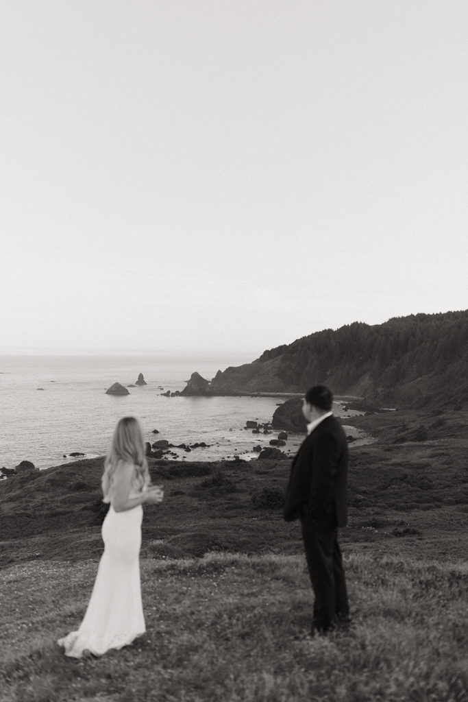 couple looks on Oregon Coast at adventure elopement 