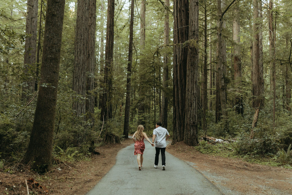 couple runs through woods at redwoods park engagement session