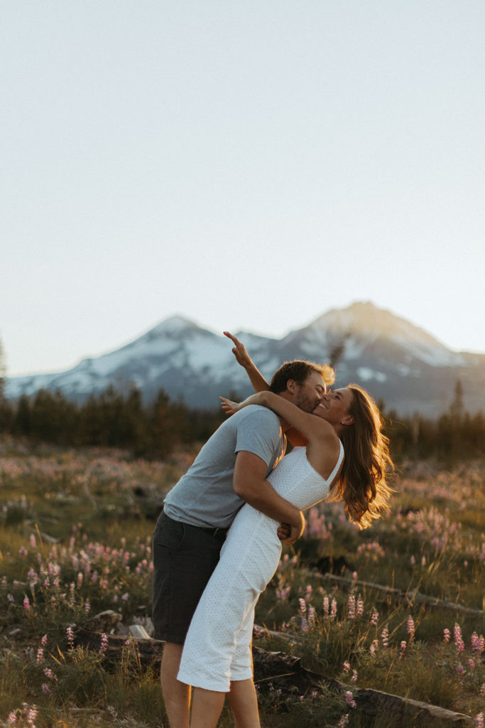 couple embraces in field at sunset Oregon engagement shoot