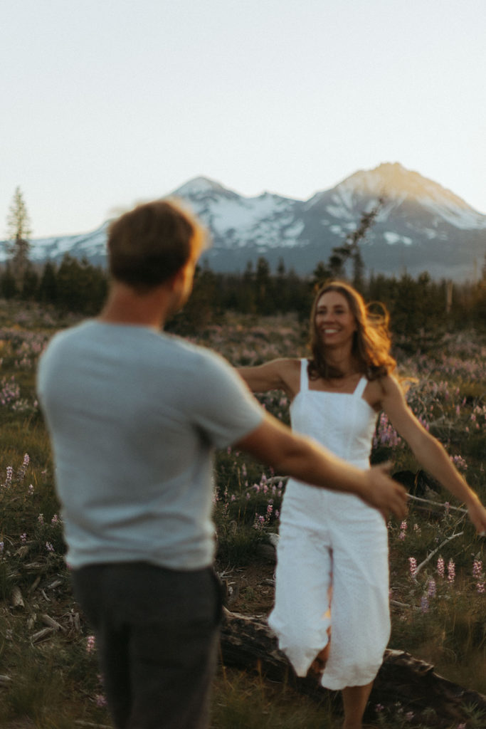couple runs through field at sunset Oregon engagement shoot