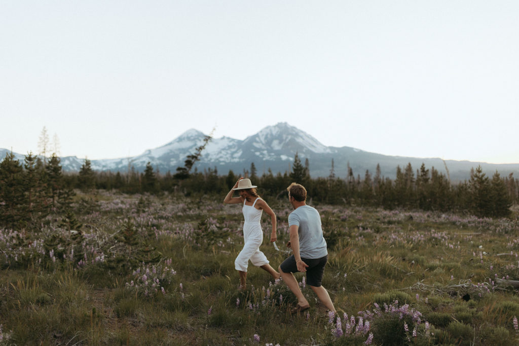 couple runs through field at Oregon engagement session