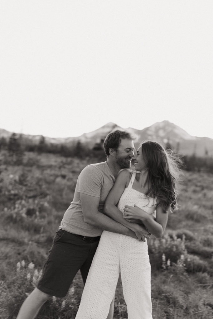 couple embraces in field at Bend Oregon engagement shoot