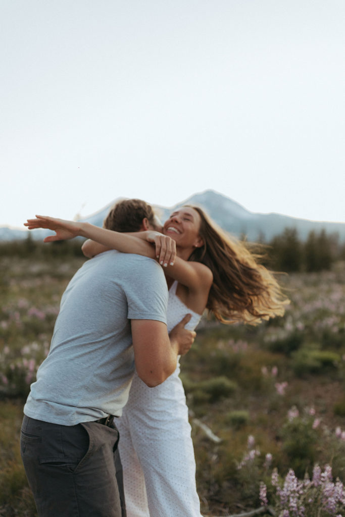 couple embraces in sunset field at engagement session