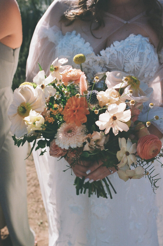 bride holds colorful wildflower wedding bouquet 
