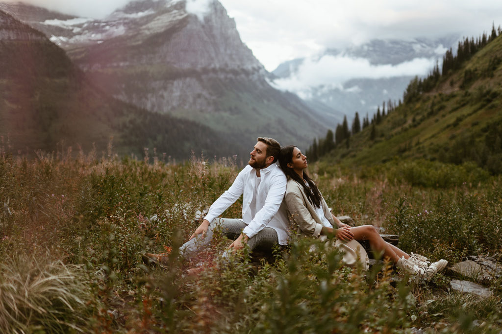 couple sits in field at sunrise Montana engagement session