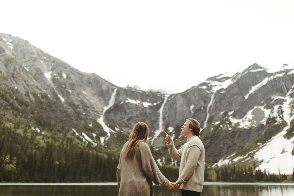 couple stands beside Avalanche Lake at Montana engagement
