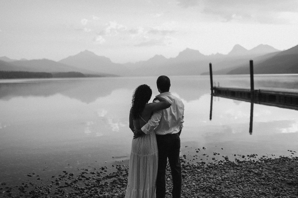couple stands by lake at Montana sunset engagement session