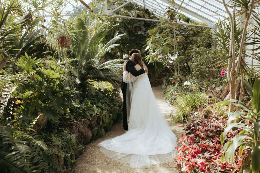 couple embraces during greenhouse first look at California wedding