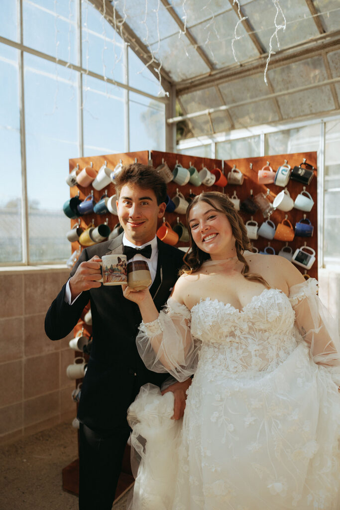 couple cheers with mugs at California greenhouse wedding