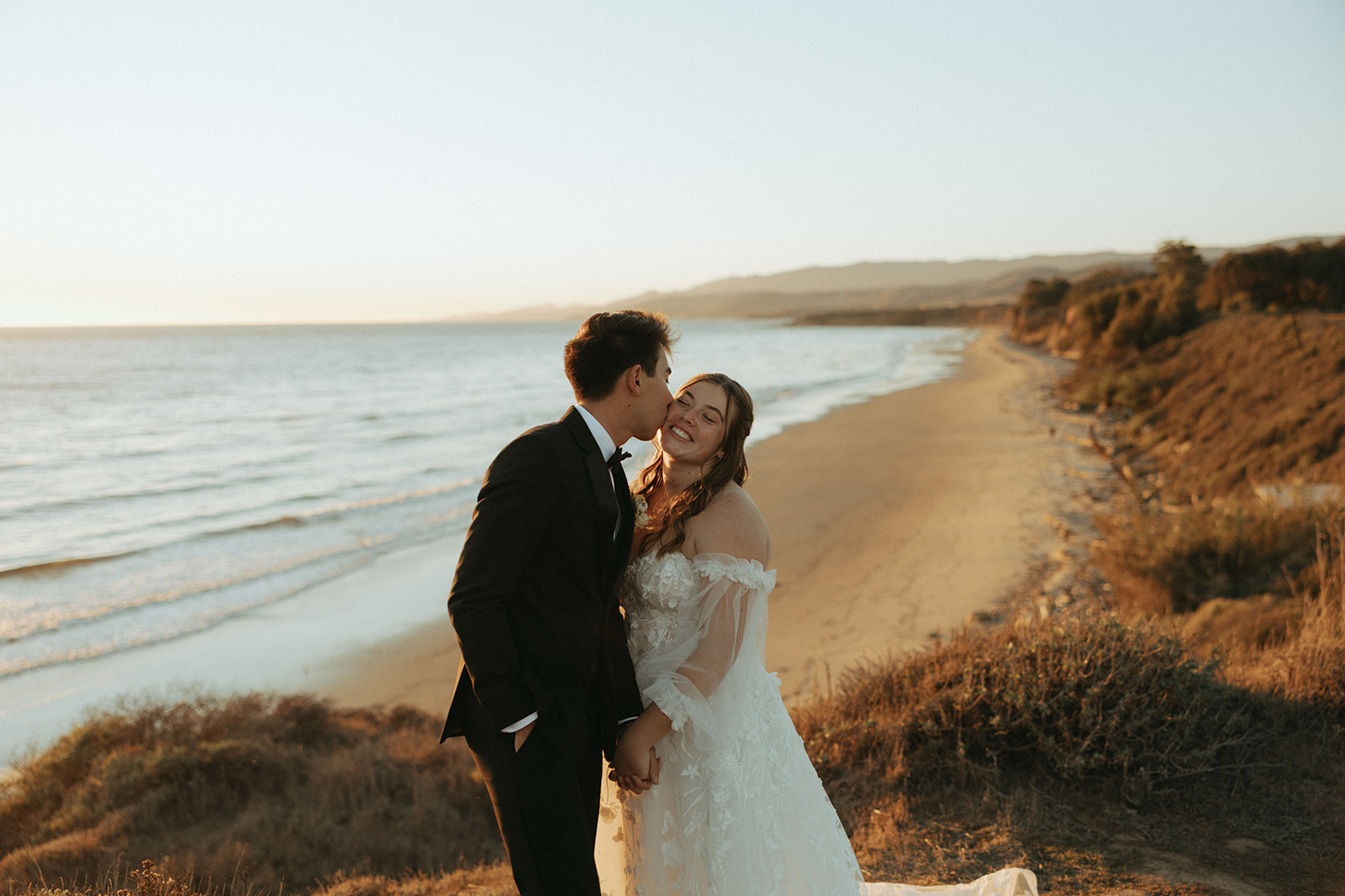 couple kisses at California coast sunset wedding