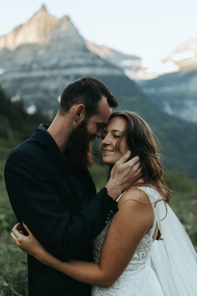 couple embraces besides snow-covered mountains 