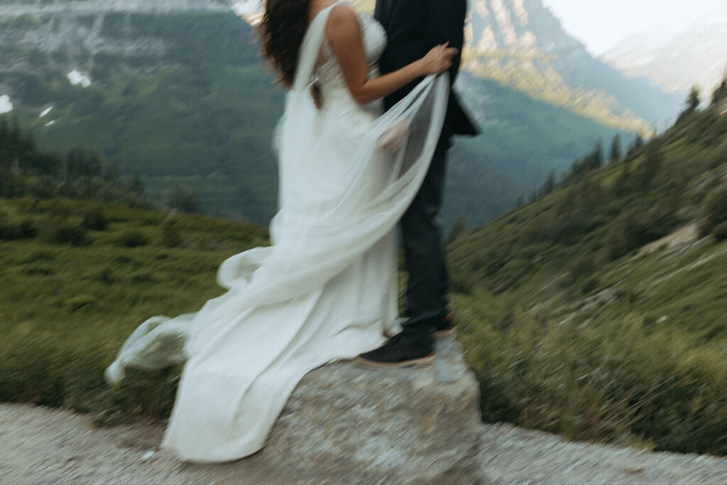 couple stands on rock embracing at elopement