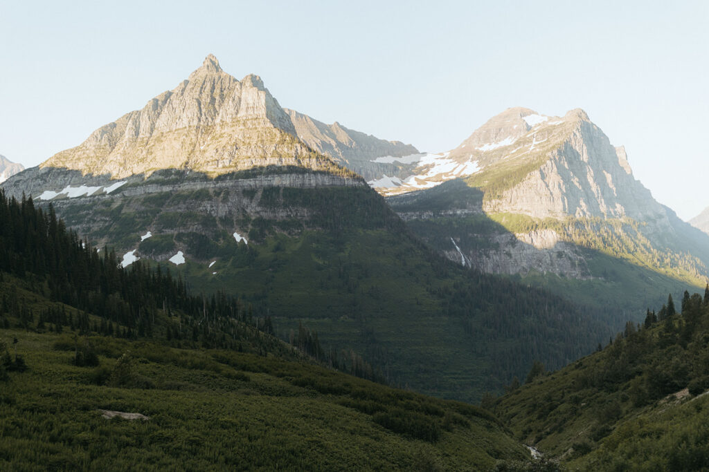 sunrise over the snowy mountaintops at glacier national park