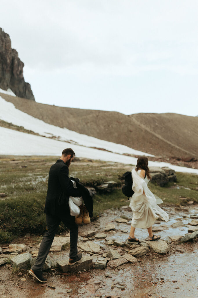 couple walks through mud at outdoor elopement