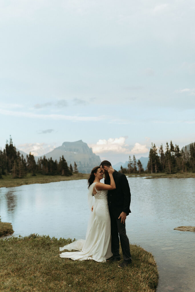 couple embraces beside lake at mountain outdoor adventure elopement