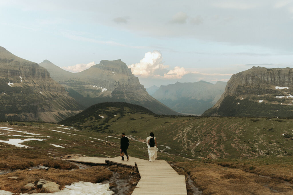 couple walks on path during glacier national park elopement