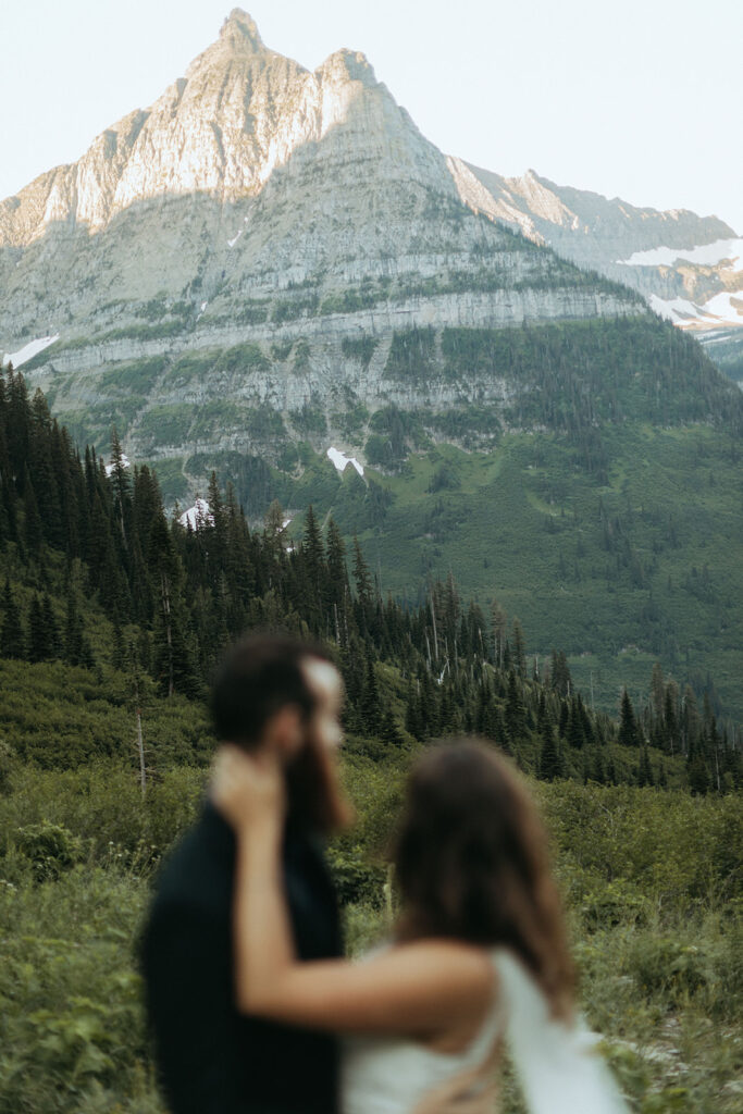 couple embraces in front of mountain at outdoor adventure elopement