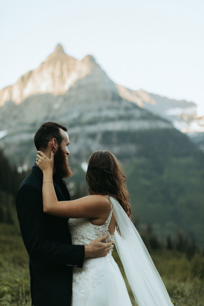 couple embraces besides snow-covered mountains 