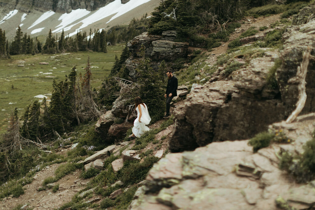 couple hikes down mountain at Glacier National park elopement
